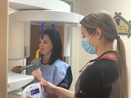 Team member assisting patient in machine